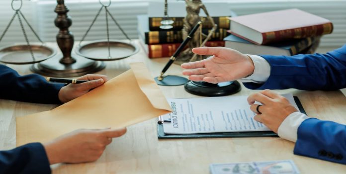 Análise-Jurídica Duas pessoas analisando e trocando documentos.