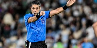 FPF exigirá que árbitros se cadastrem em sistema de autoexclusão de apostas Árbitro de futebol, homem, apita e faz gesto com a mão esquerda apontando para um jogador.