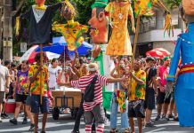 Foto tirada de Carnaval de rua em Belo Horizonte, com dezenas de foliões reunidos.