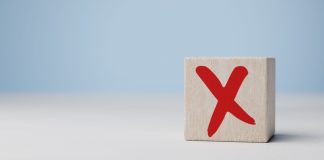 FEBRALOT protesta contra suspensão da BetCaixa Cubo com a letra X vermelha escrito sobre a mesa com fundo claro