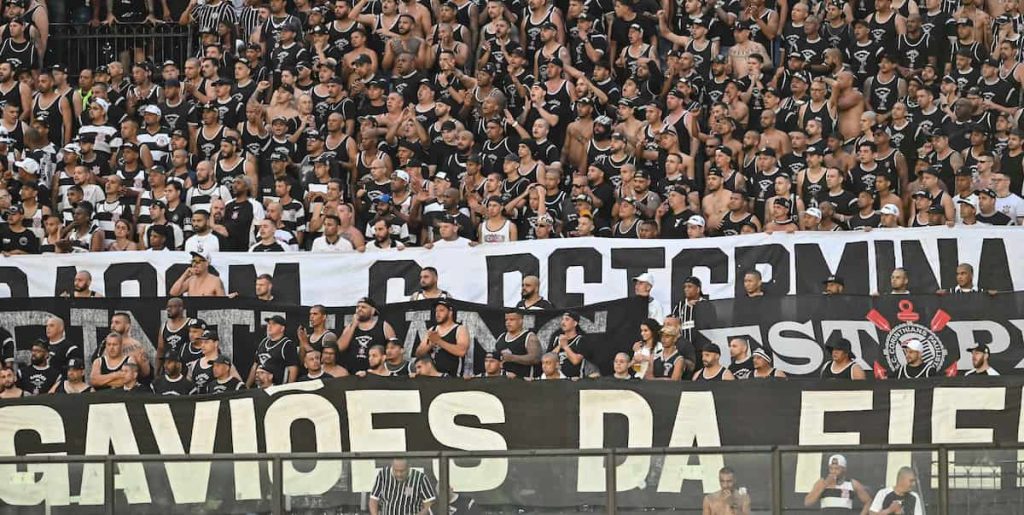 Foto tirada de milhares de torcedores do Corinthians com uma faixa da torcida organizada Gaviões da Fiel.