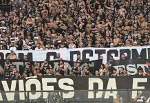 Foto tirada de milhares de torcedores do Corinthians com uma faixa da torcida organizada Gaviões da Fiel.