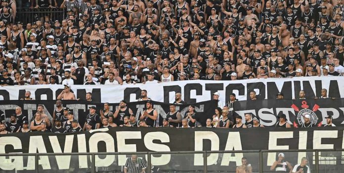 Foto tirada de milhares de torcedores do Corinthians com uma faixa da torcida organizada Gaviões da Fiel.