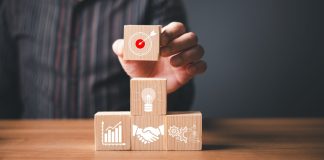 Flutter Brazil une-se ao IAB Brasil para elevar padrões de publicidade Um homem organizando blocos de madeira sobre a mesa que simbolizam objetivos de negócios