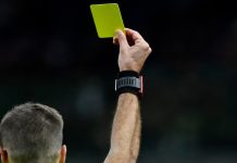 Polícia investiga grupo que lucrou 650% com apostas envolvendo cartões amarelos no Campeonato Carioca Juiz de futebol mostrando um cartão amarelo.