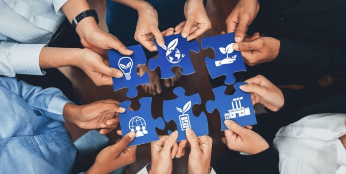 Kaizen Foundation firma parceria com Resolution Project para incentivar projetos de inovação social Pessoas segurando peças de quebra-cabeça que se encaixam