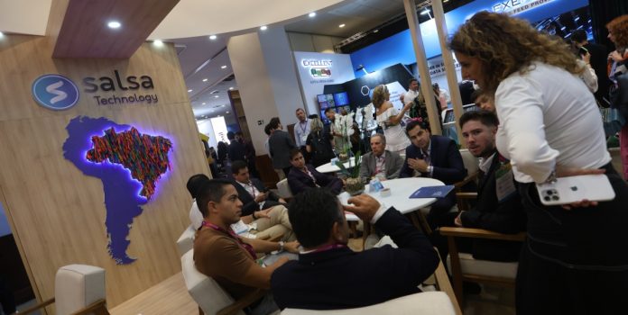 Salsa-Technology-confirma-participação-no-SBC-Summit-Rio-2026 Participantes sentados conversando em frente ao logo da Salsa Technology no SBC Summit Rio 2025