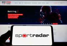Pessoa segurando um celular com um logo da Sportradar.