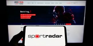 Pessoa segurando um celular com um logo da Sportradar.