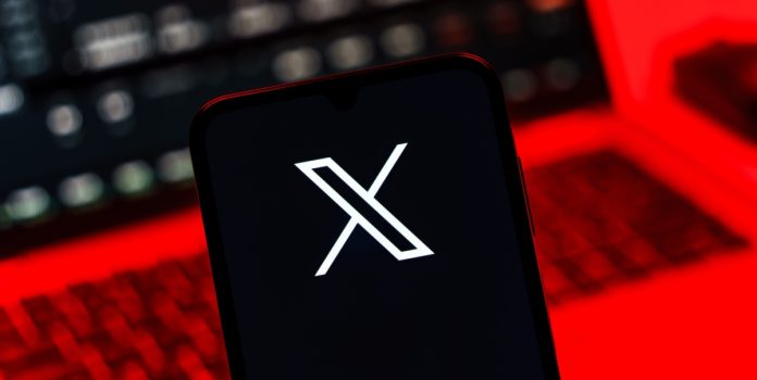 Logo do X no smartphone com fundo avermelhado
