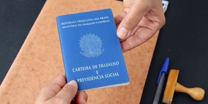 thiago-balieiro-sorte-online-mercado-de-trabalho-apostas-brasil Duas mãos segurando a Carteira de Trabalho do Brasil