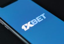 1xBet anuncia parceria com Carlos Prates, lutador do UFC A tela de um celular com o logotipo da 1xBet.