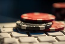 Fichas de cassino em cima de um teclado de computador.