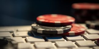 Como iniciar o seu live casino em 2026: o que considerar da operação à tecnologia Fichas de cassino em cima de um teclado de computador.