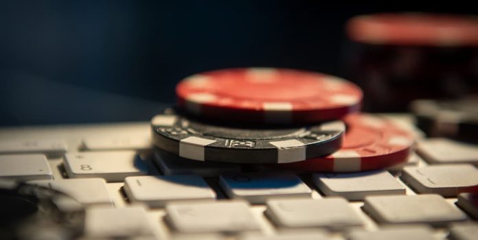 Fichas de cassino em cima de um teclado de computador.
