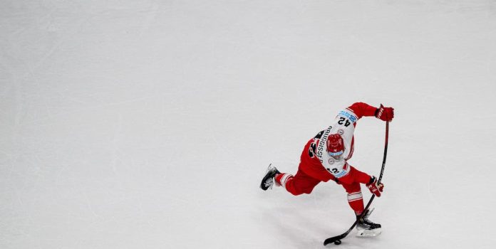 Hockey Jogador de hockey conduzindo um disco.