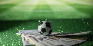 Ênio se torna réu por manipulação de apostas esportivas e lavagem de dinheiro Bola de futebol sobre notas de 100 dólares.