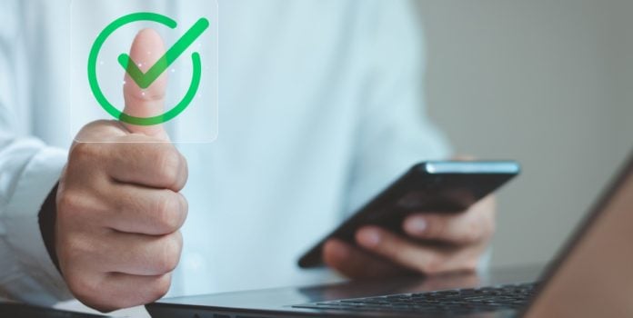 IBJR-e-ANJL-apoiam-Resolucao-do-CMN-que-restringe-mercado-preditivo-no-Brasil- Homem sentado fazendo o sinal de joinha enquanto mexe no celular