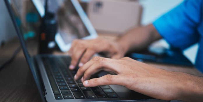 Humano fazendo vigilância por meio de um laptop.