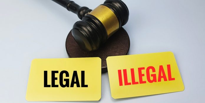 Sorte-Online-reforca-importancia-de-diferenciar-casas-de-apostas-online-licenciadas-pela-SPA Malhete de juiz com dois cartões amarelos à frente, escritos “Legal” e “Illegal”