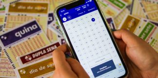 ANEL propõe modernização da Loteria Federal Uma pessoa acessando o site da Caixa para apostar na Quina e diveros volantes ao fundo