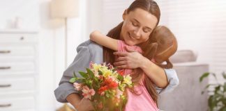 Ana Gaming lança campanha para celebrar o Dia das Mães Mãe segurando um buquê de flores e abrançando a filha