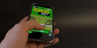 Uma pessoa usando o celular para fazer apostas esportivas.