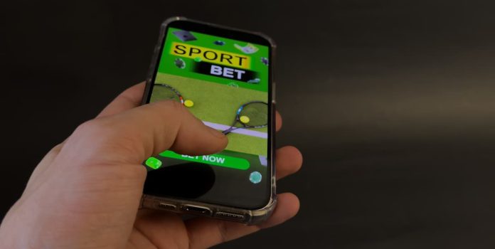 Aposta-Celular Uma pessoa usando o celular para fazer apostas esportivas.