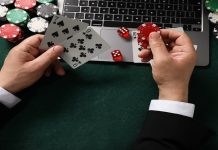 Daniel Fortune detalha projeto de enfrentamento ao jogo problemático Homem segurando cartas e fichas em frente de um laptop.