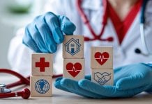 Um médico segurando cubos de madeira com ícones que representam saúde e caridade.