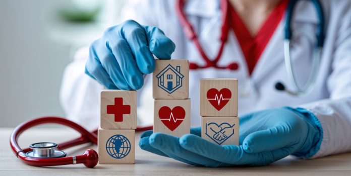 Pinheirinho-apresenta-PL-para-destinar-recursos-de-apostas-a-Santas-Casas-e-hospitais-filantropicos Um médico segurando cubos de madeira com ícones que representam saúde e caridade.