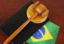 AGU defende suspensão de lei do RS que restringe publicidade de apostas Um malhete sobre livro de processos com a bandeira do Brasil sobre a mesa