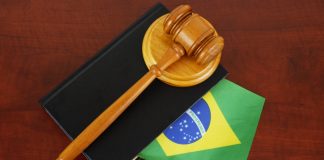 AGU defende suspensão de lei do RS que restringe publicidade de apostas Um malhete sobre livro de processos com a bandeira do Brasil sobre a mesa