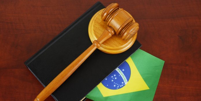 AGU-manifesta-se-a-favor-da-suspensao-de-lei-gaucha-contestada-pela-ANJL Um malhete sobre livro de processos com a bandeira do Brasil sobre a mesa