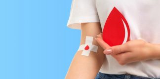Mulher segurando uma gota de sangue em desenho para representar a doação de sangue