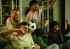 Betsul anuncia patrocínio ao programa Os Donos da Bola Grupo de torcedores assistindo TV com uma bola na mão.