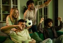 Betsul anuncia patrocínio ao programa Os Donos da Bola Grupo de torcedores assistindo TV com uma bola na mão.