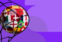 CAIXA Loterias lança Copa da Loteca voltada à Copa do Mundo de 2026 Uma bola de futebol, estampada com bandeiras de diferentes países, batendo na rede do gol sobre um fundo roxo