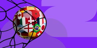 CAIXA Loterias lança Copa da Loteca voltada à Copa do Mundo de 2026 Uma bola de futebol, estampada com bandeiras de diferentes países, batendo na rede do gol sobre um fundo roxo