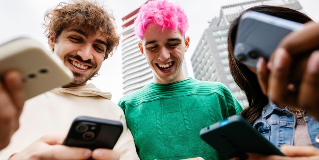 Grupo de jovens masculinos fazendo apostas em seus celulares.