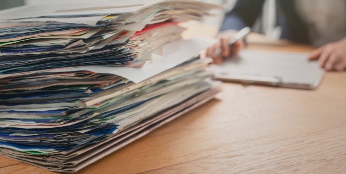 Pilha de documentos para serem analisados em uma investigação.