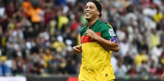 Ronaldinho lança parceria com CreedRoomz para jogos ao vivo Ronaldinho correndo em jogo de futebol.