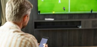 68% dos brasileiros defendem proibição de patrocínio de apostas no futebol, segundo pesquisa Ipsos-Ipec Homem assistindo futebol na TV enquanto faz apostas em seu smartphone.