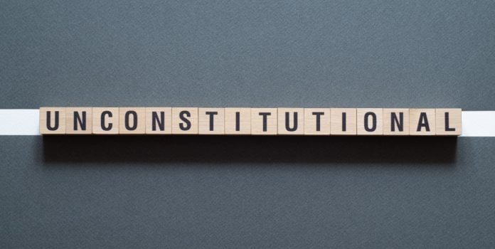 Advogado-afirma-que-decreto-que-proibe-publicidade-de-apostas-no-RJ-e-inconstitucional A palavra inconstitucional escrita em inglês com cubos de madeiras alinhados