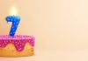 Bolo de aniversário com vela em formato de número 7 acesa