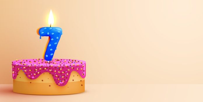 Betsul-celebra-sete-anos-de-operacao-no-Brasil Bolo de aniversário com vela em formato de número 7 acesa