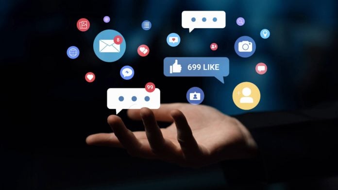 Ícones de redes sociais projetados sobre uma mão