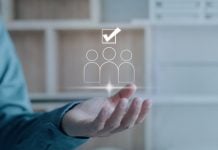 Uma mão projetando três bonecos e o símbolo de aprovado, representando o conceito de excelência em negócios