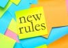 Post-its coloridos com um deles escrito "novas regras" em inglês