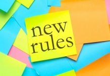 Post-its coloridos com um deles escrito "novas regras" em inglês